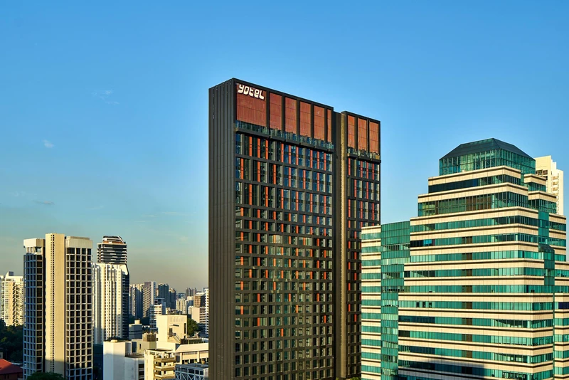 YOTEL tower with dark facade and orange accent panels in Orchard Road skyline