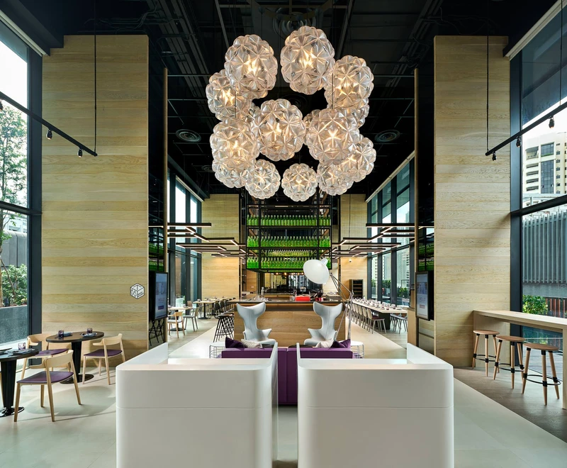Double-height atrium with glass sphere chandelier and modular seating