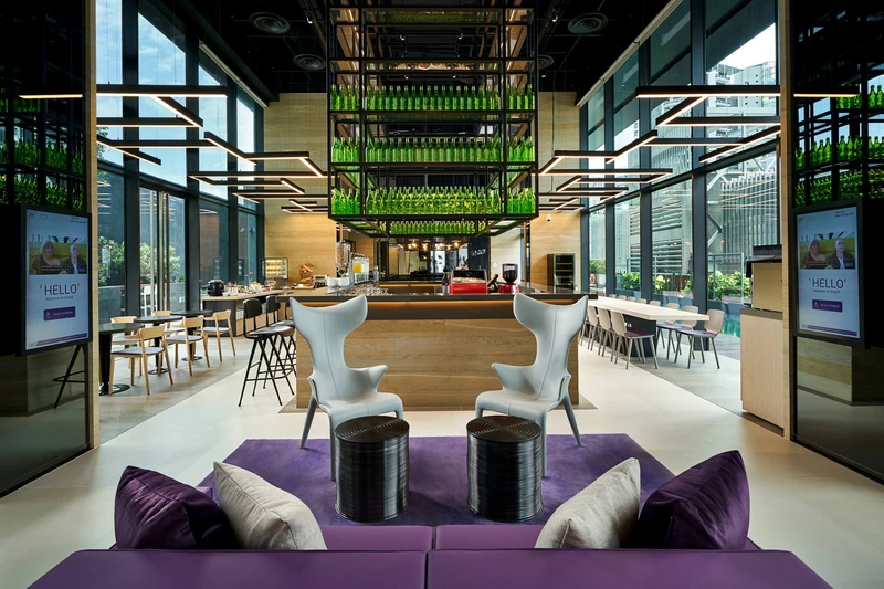 Hotel lobby with purple sofas, welcome screens and glass bottle chandelier