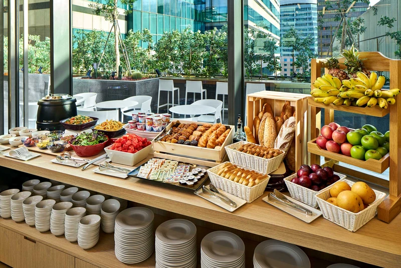 Breakfast buffet with fresh bread, fruit and pastries in morning light