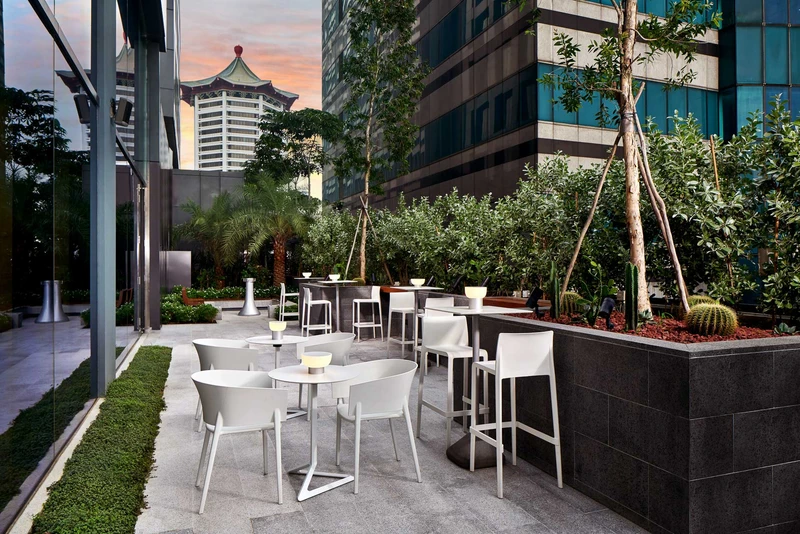 Sunset terrace dining with white chairs, cacti and pagoda rooftop view