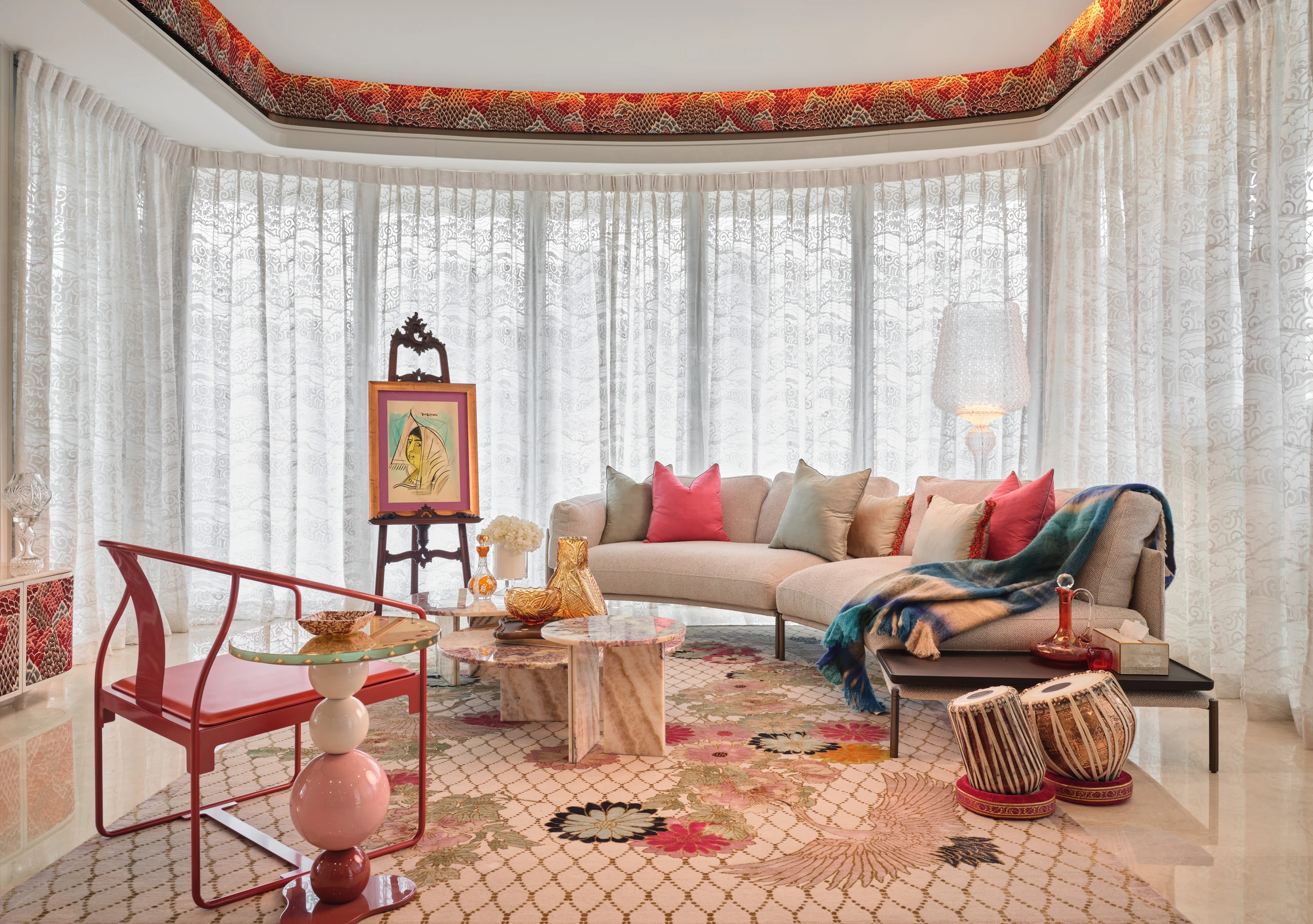 Living room with floor-to-ceiling windows, patterned textiles and colourful seating