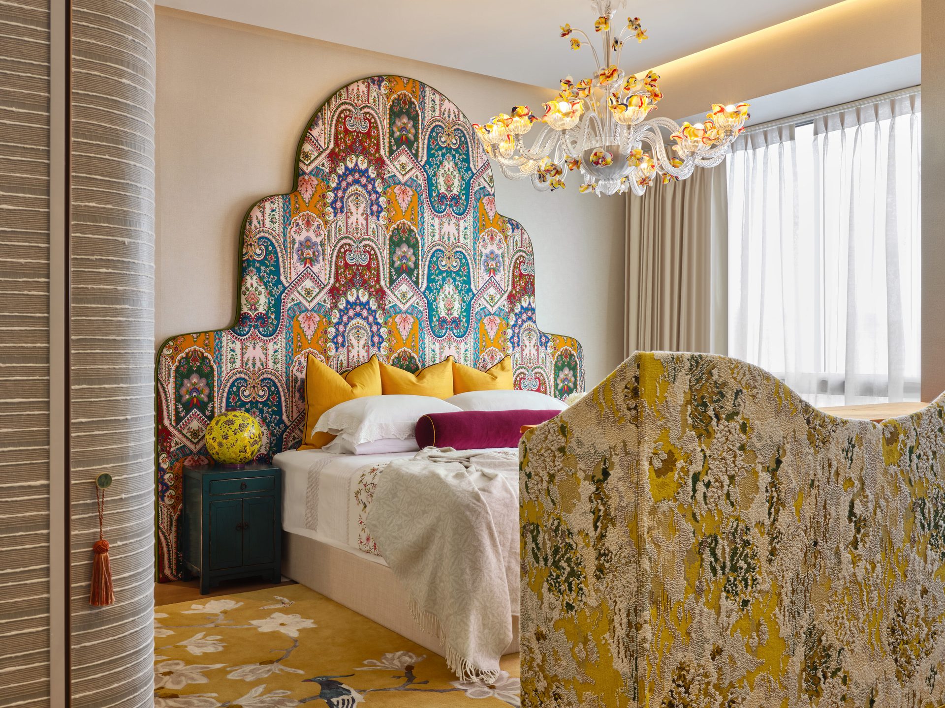 Bedroom with vibrant patterned headboard and soft furnishings