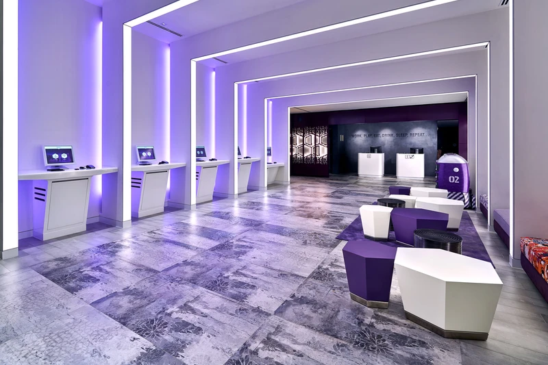 YOTEL Singapore lobby with purple LED lighting and robot concierges