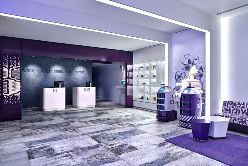 Futuristic lobby with robot concierges and purple LED lighting