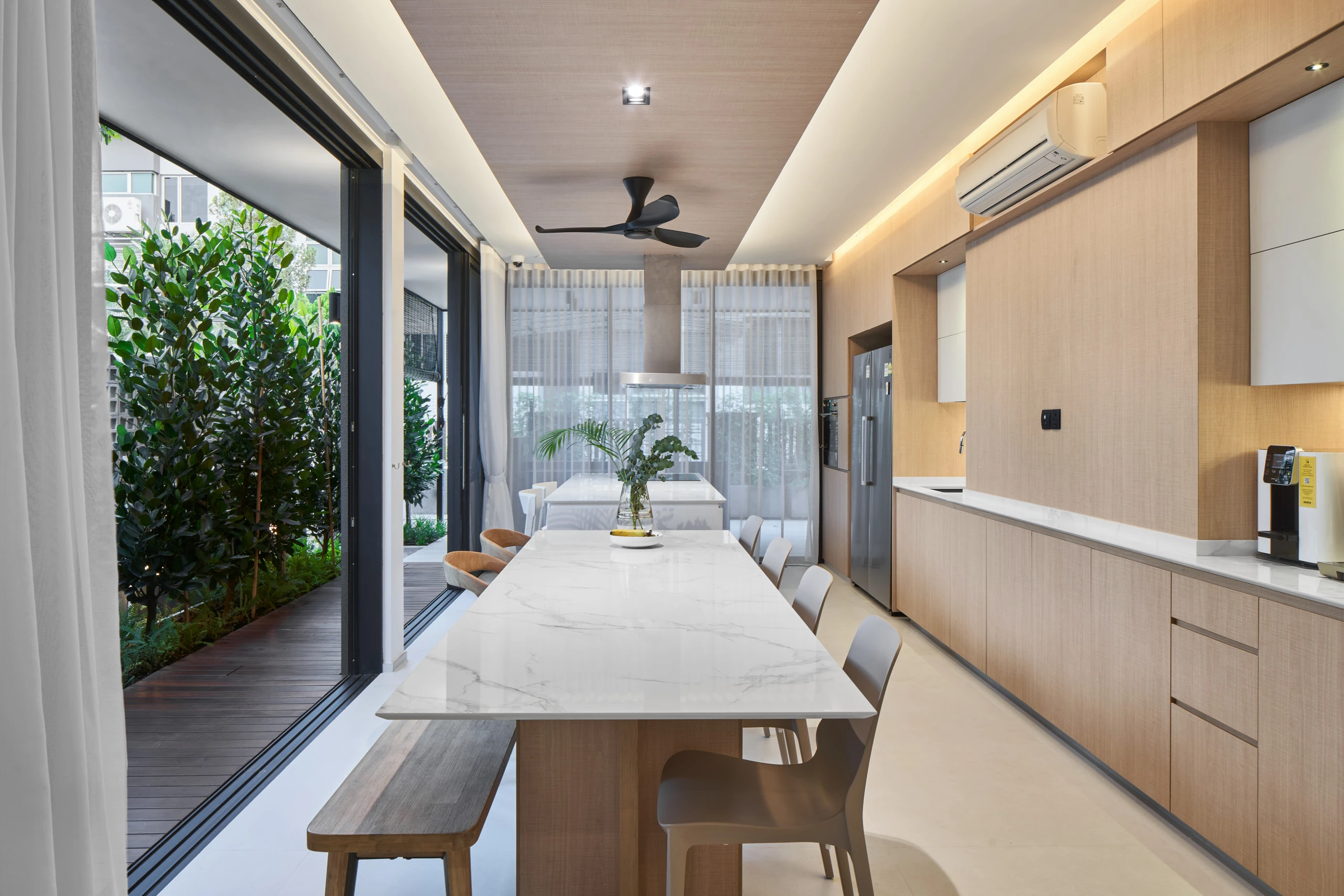 Dining area with open-plan kitchen in modern residential project.
