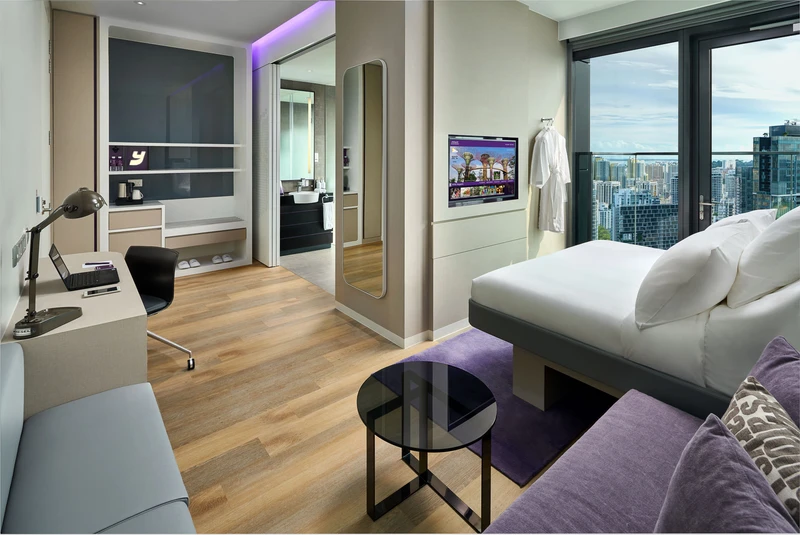 Deluxe room with purple sofa, work desk and panoramic city views