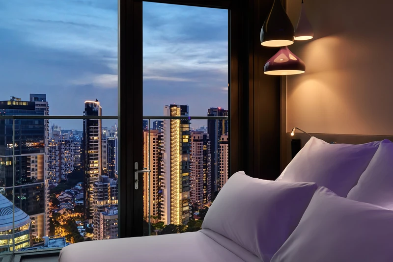 YOTEL Singapore deluxe room bed detail with purple headboard