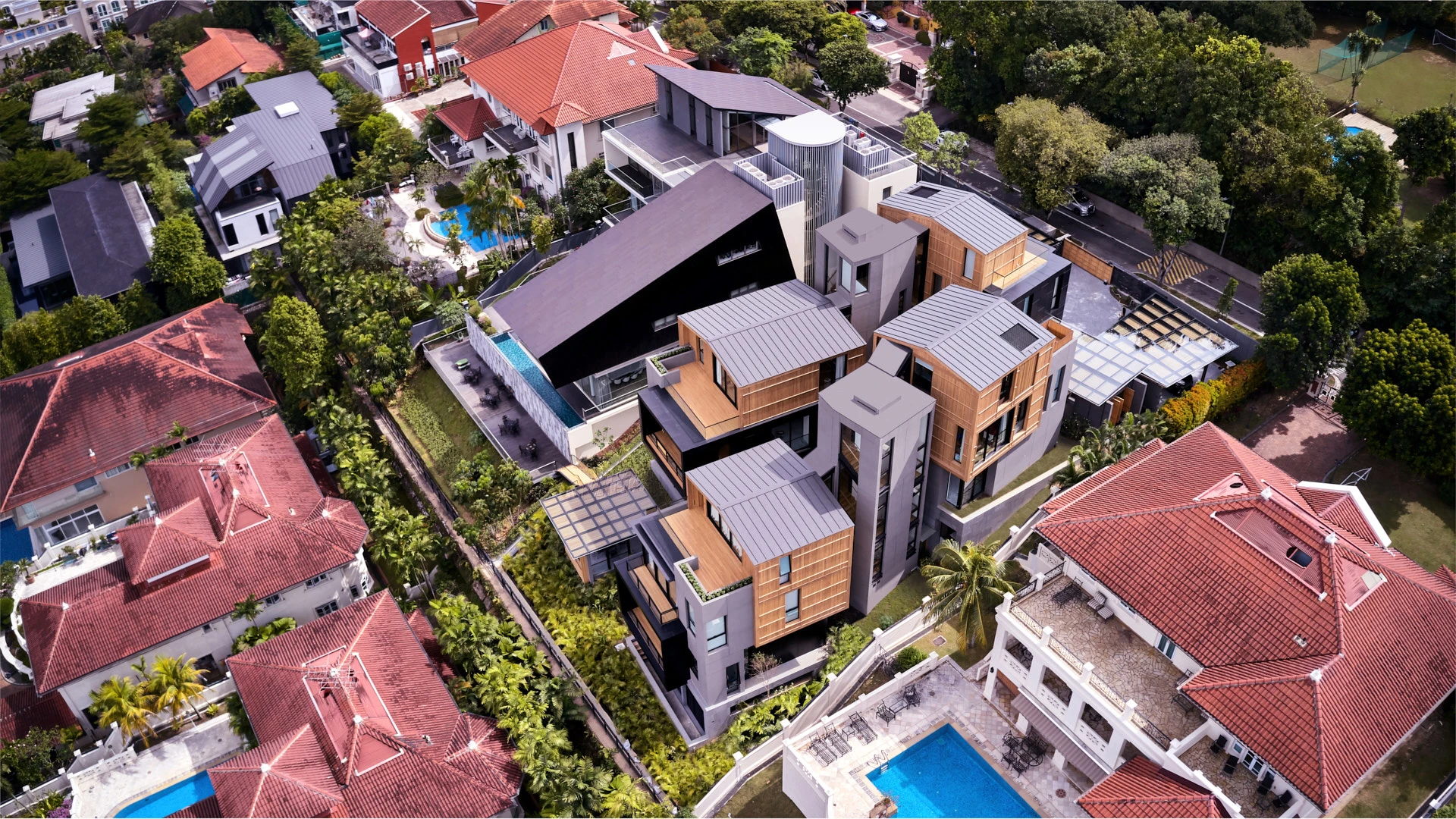 Oblique aerial showing dark angular wing, pool terrace and timber volumes