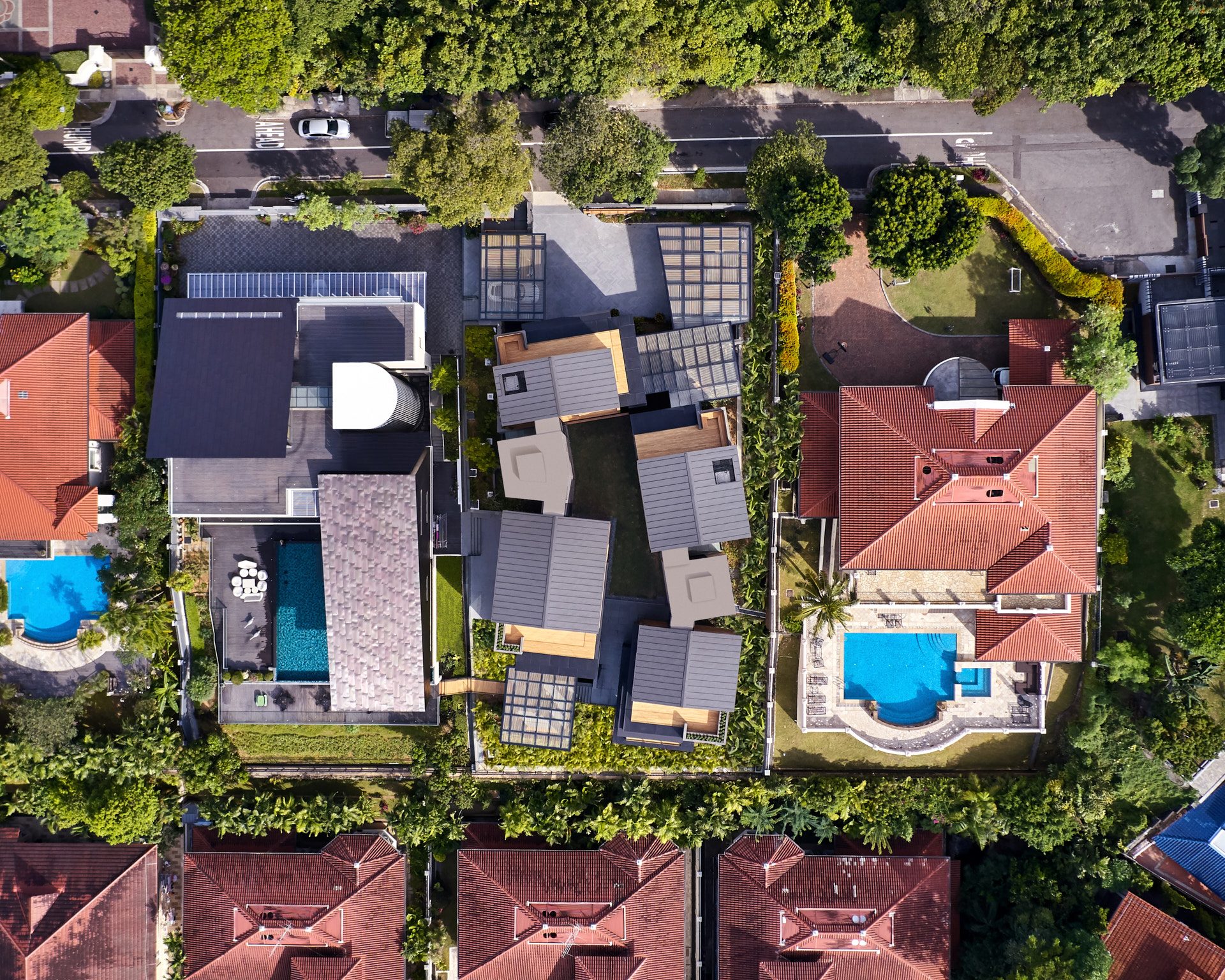 Top-down view of grey standing-seam roofs and timber penthouses