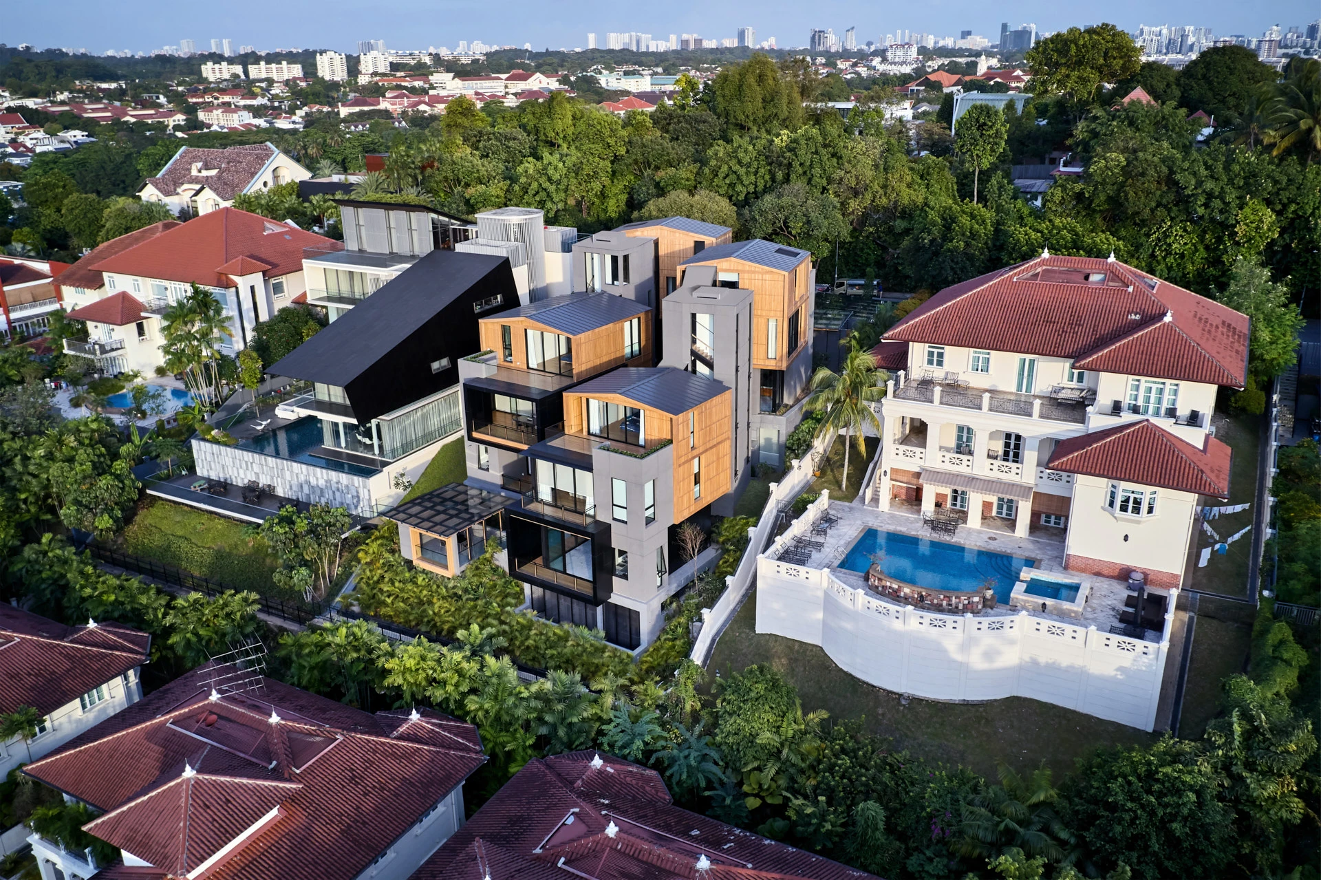 High aerial of modern house among colonial bungalows at golden hour
