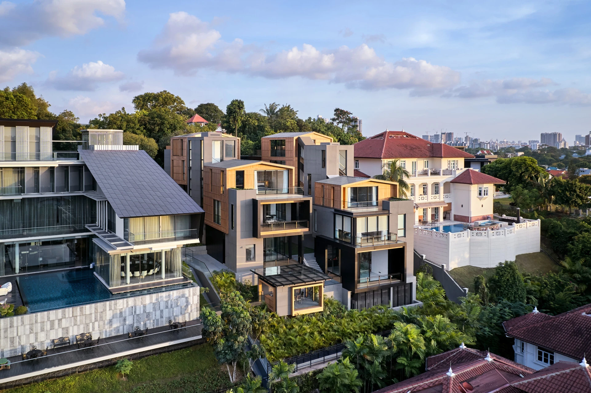 Wider aerial of interlocking box house with neighbouring infinity pool