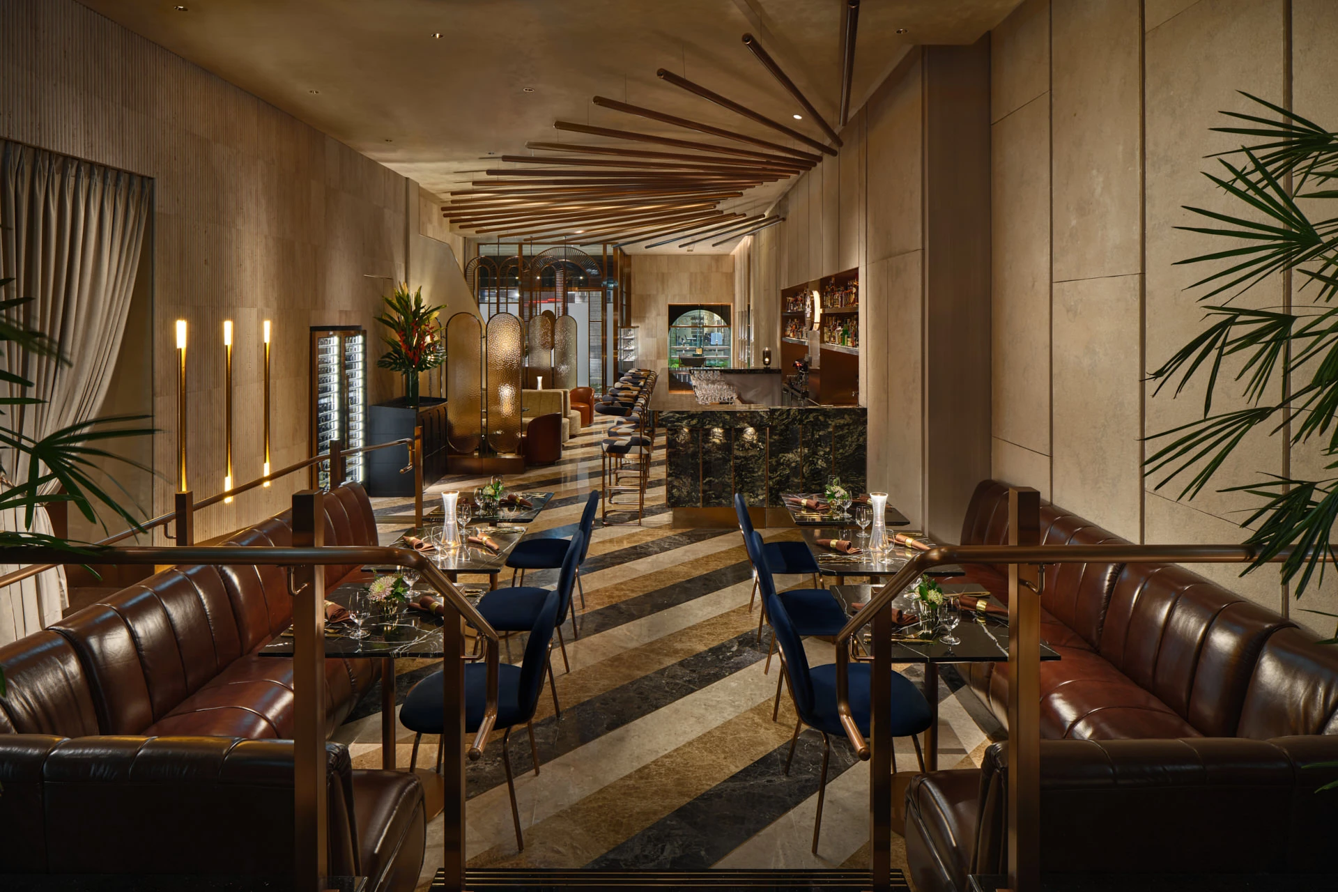 Dining corridor with brass rail dividers, striped marble floor and copper ceiling