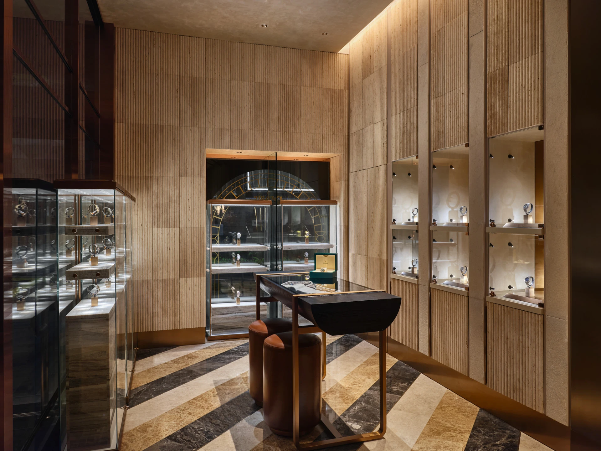 Watch showroom with fluted travertine walls and glass vitrines