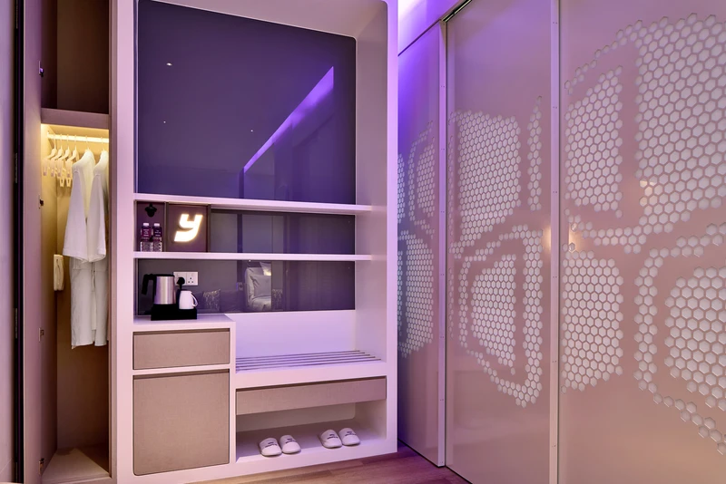 Wardrobe with bathrobes, illuminated Y logo and purple mood lighting