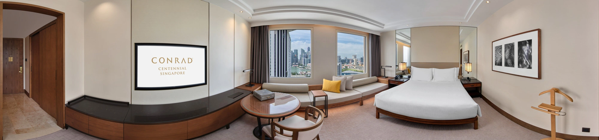 360 panorama of Conrad Centennial Singapore king room with bay window sofa and Marina Bay skyline views