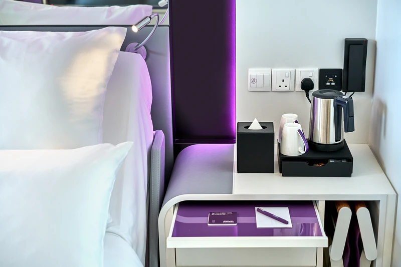 Bedside detail with kettle, tea set and purple LED headboard