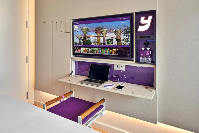 Cabin room with fold-down desk, smart TV and purple accents