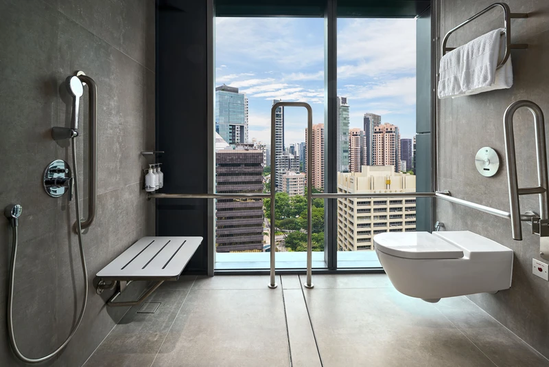 Accessible wet-room with grab bars, fold-down seat and city view
