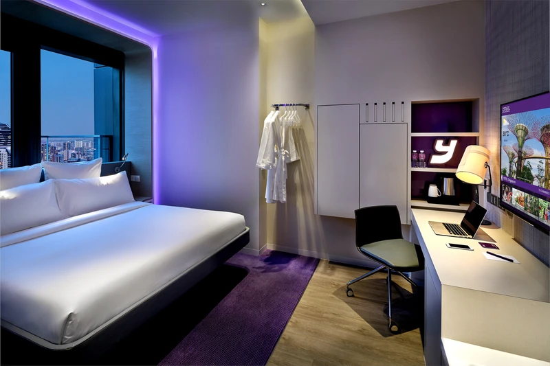 YOTEL Singapore suite bedroom at dusk with city view