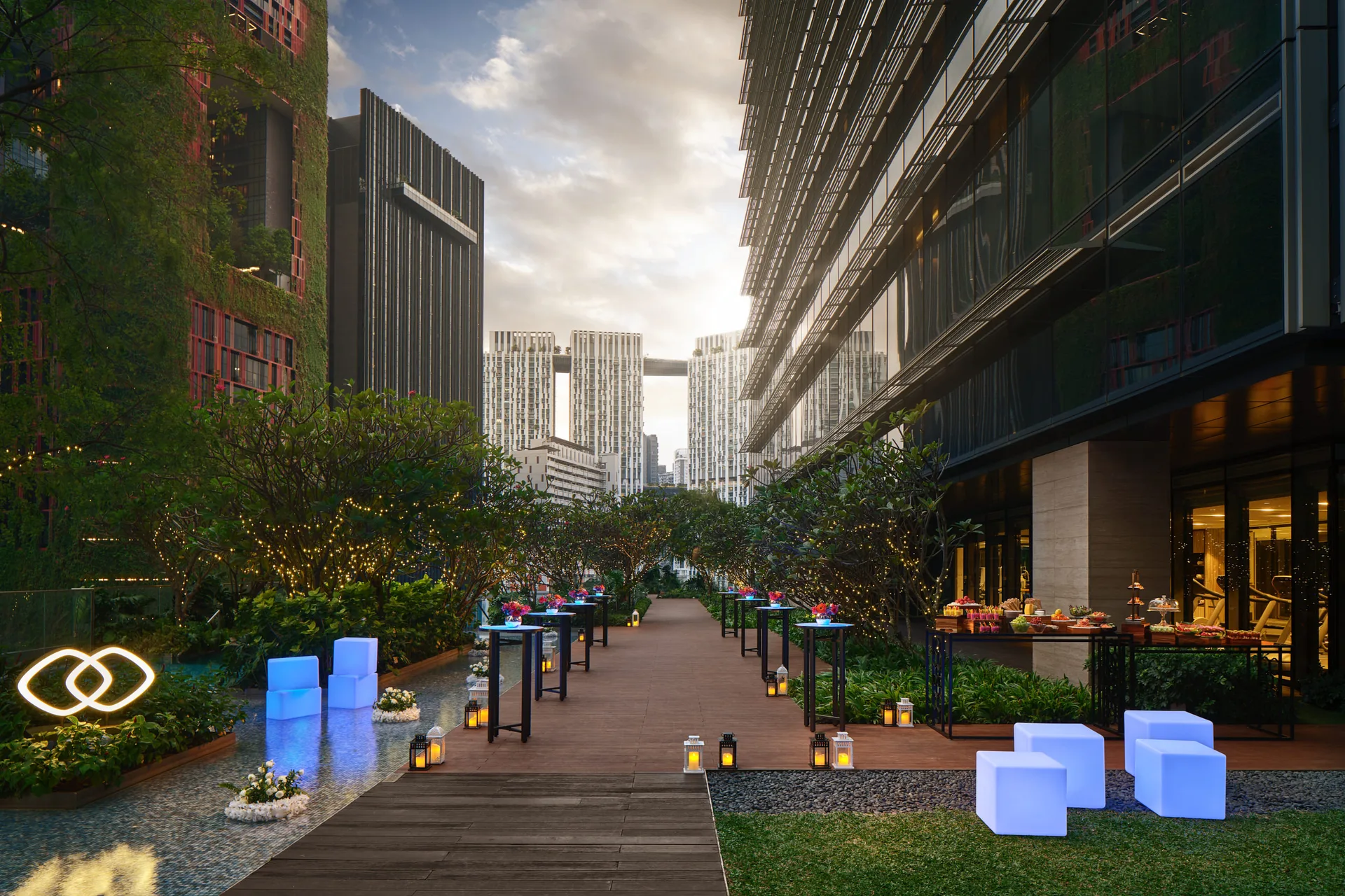 Poolside deck event setup at Sofitel Singapore City Centre in the evening with illuminated seating and downtown skyline