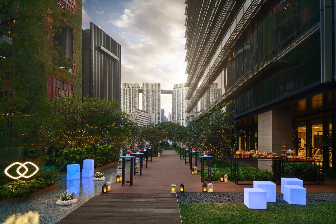 Poolside deck event setup at Sofitel Singapore City Centre in the evening with illuminated seating and downtown skyline