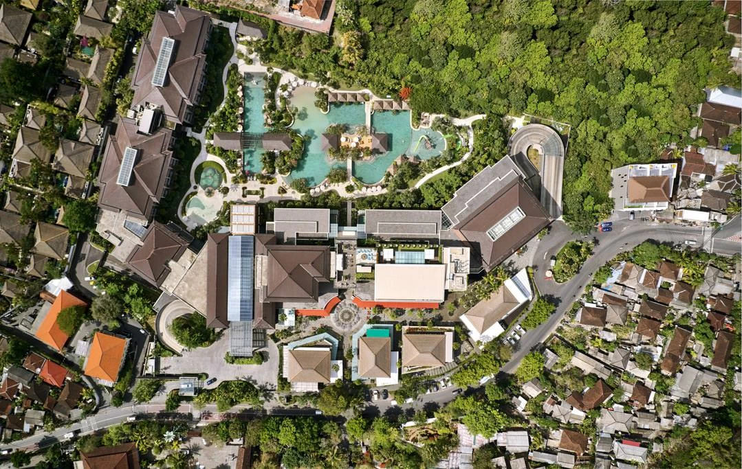 Top-down drone view of resort complex with pool and rooftop bar