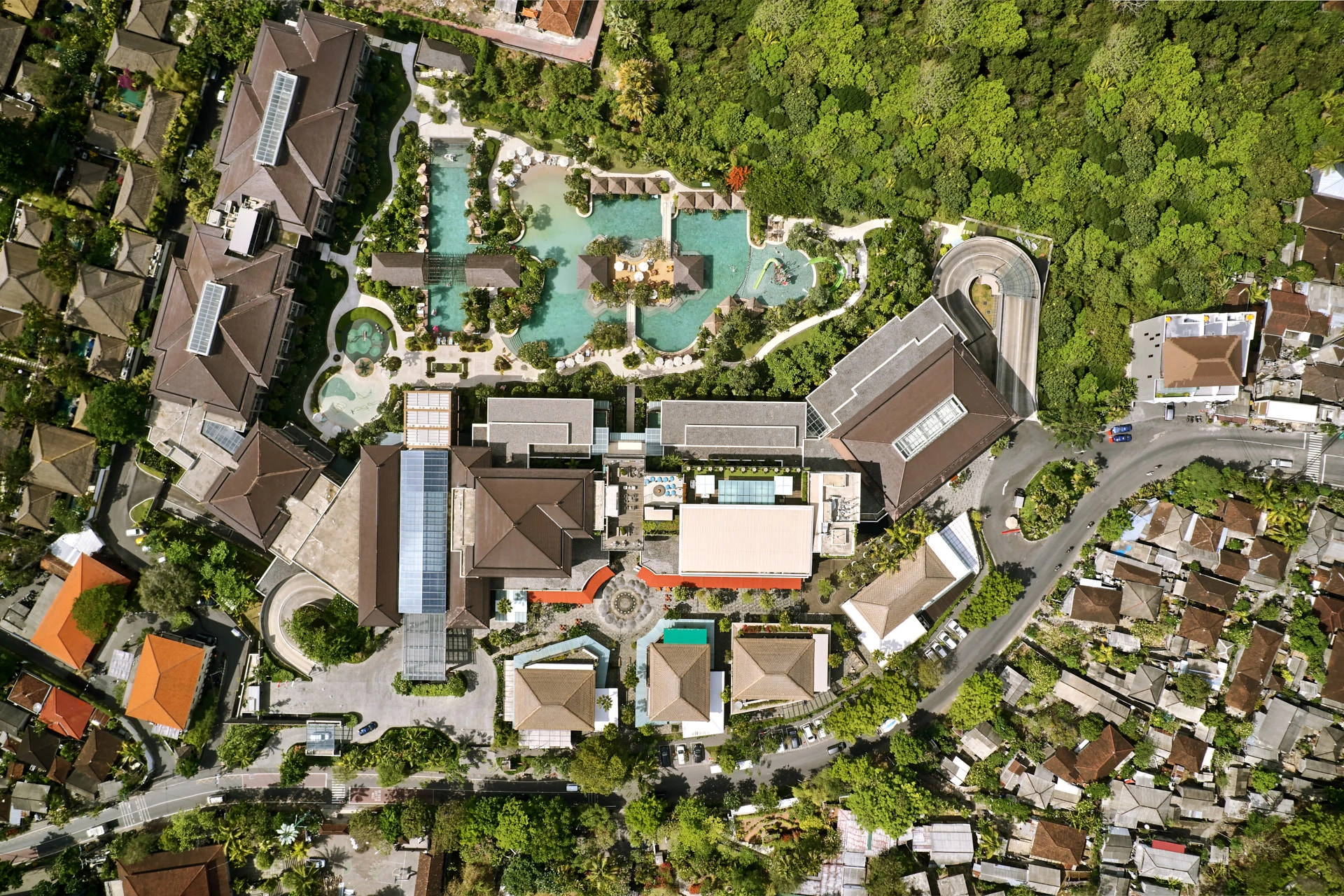 Aerial view of resort with rooftop bar, Balinese roofs and jungle canopy