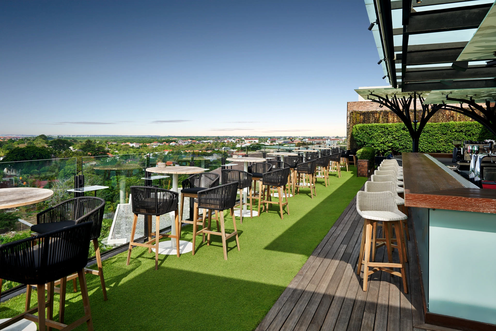 Terrace with rope chairs on turf, bar counter and coastal panorama