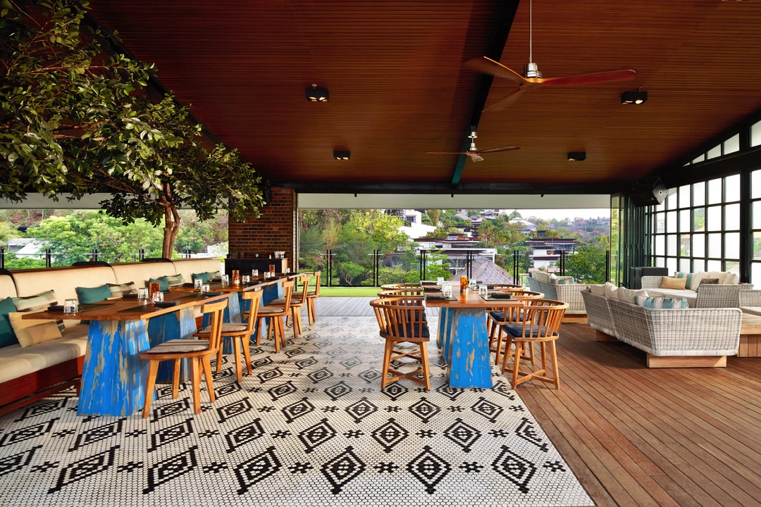 Open-sided dining with timber ceiling, mosaic floor and hillside views