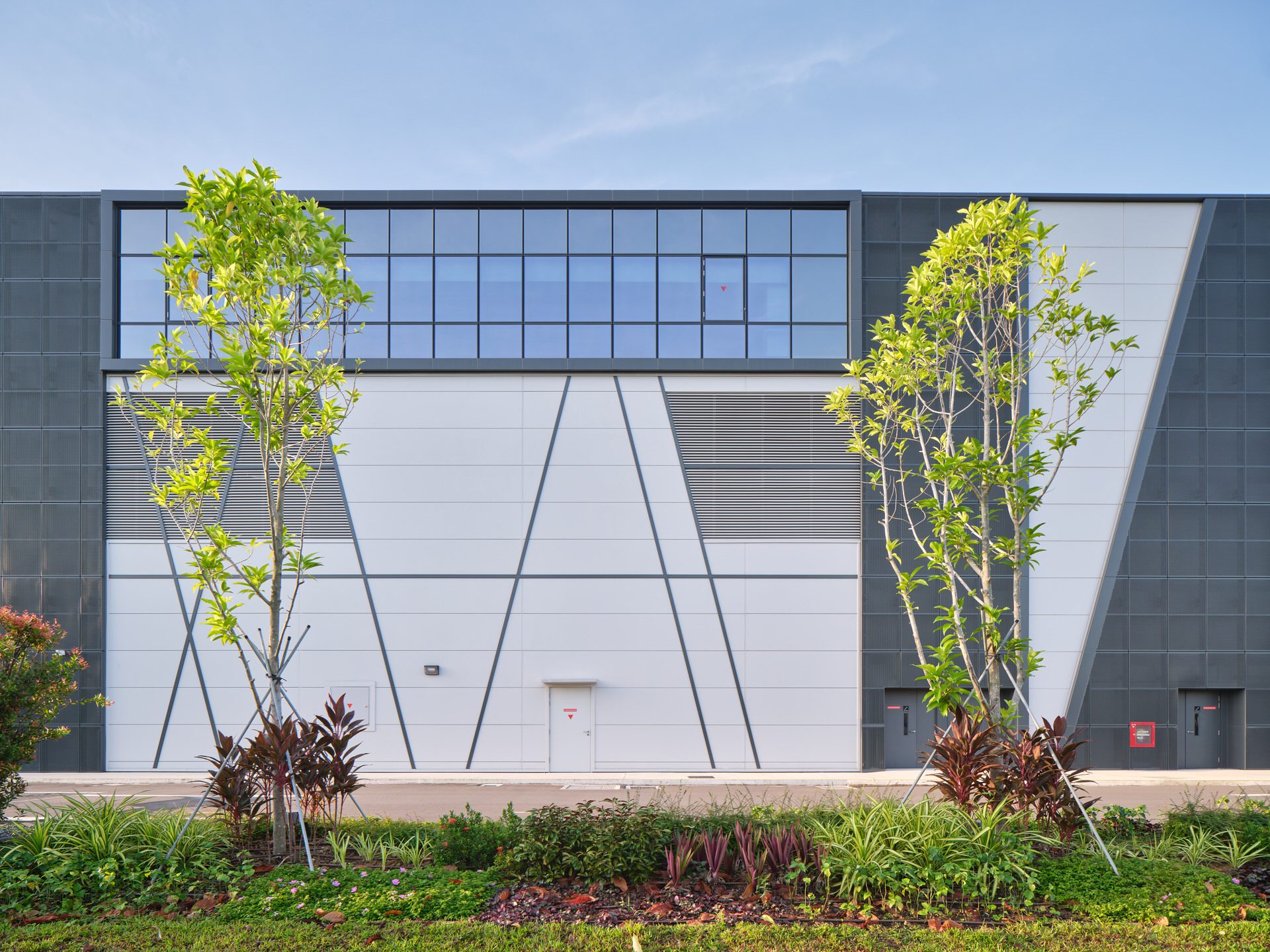 Facade detail with diagonal seam panels, louvres and clerestory glazing