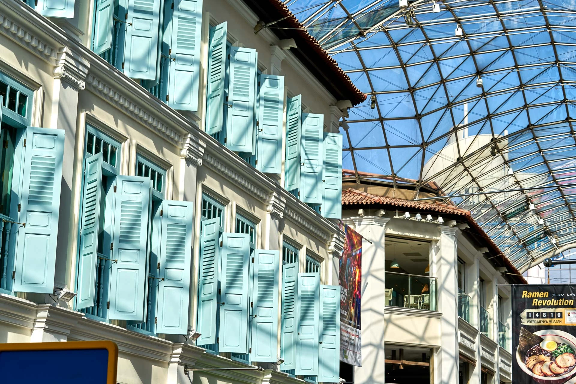 Turquoise louvered shutters on colonial facade with glass roof above - Bugis Junction Singapore detail photography
