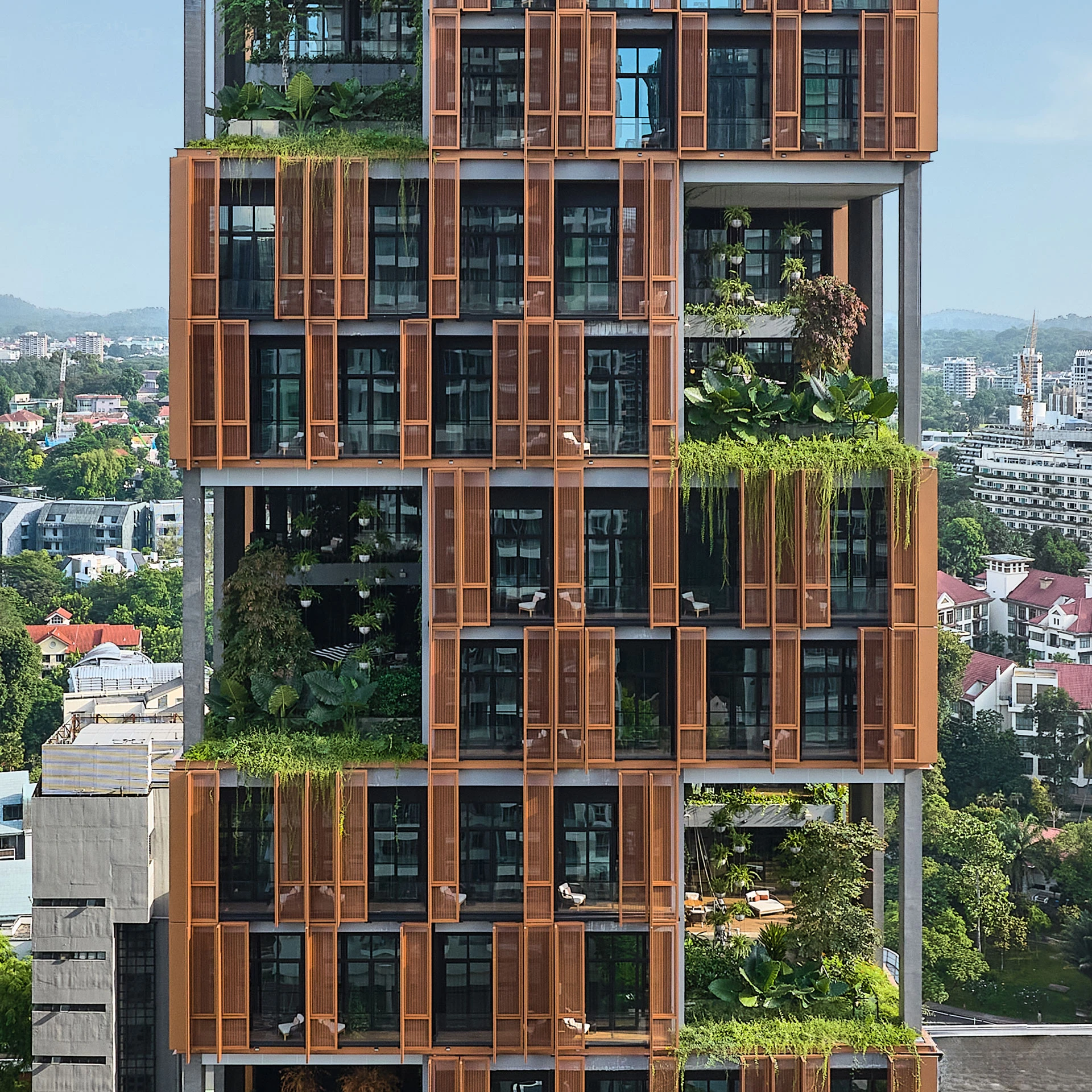 Artyzen Hotel Singapore facade detail with copper screens and cascading tropical planting
