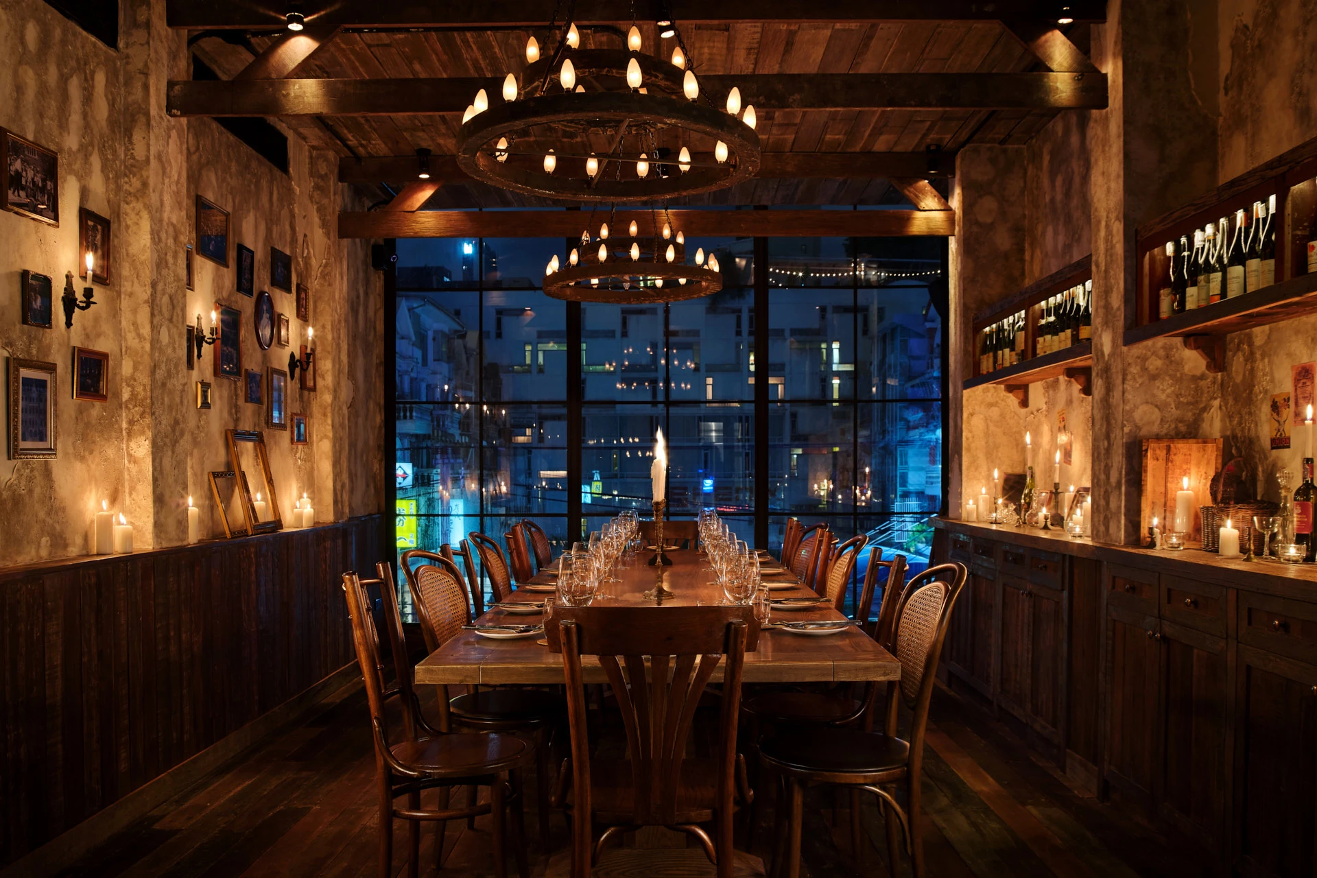 Private dining with wagon-wheel chandeliers and vintage photographs — Cantina Bangkok restaurant interior photography
