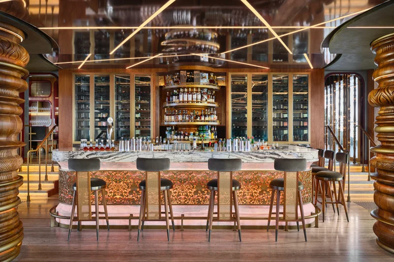 Ce La Vi rooftop bar with marble counter, carved wood columns, wine display, and mirrored ceiling with geometric lighting