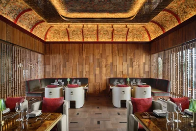 Ce La Vi private dining room with illuminated patterned ceiling, wood paneling, banquette seating, and round tables