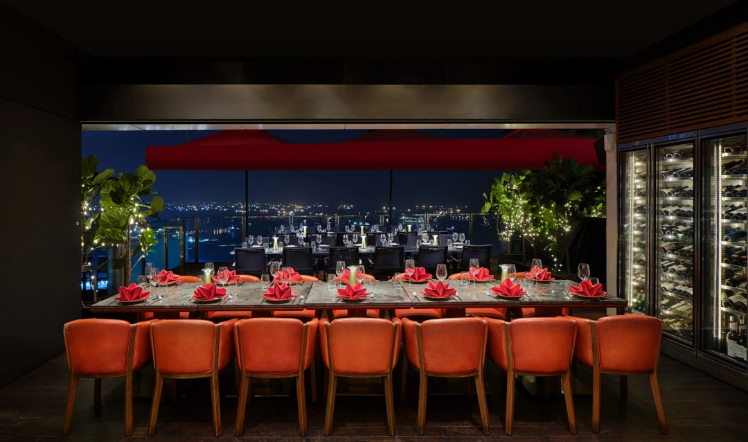 CÉ LA VI Singapore bar with orange chairs and skyline
