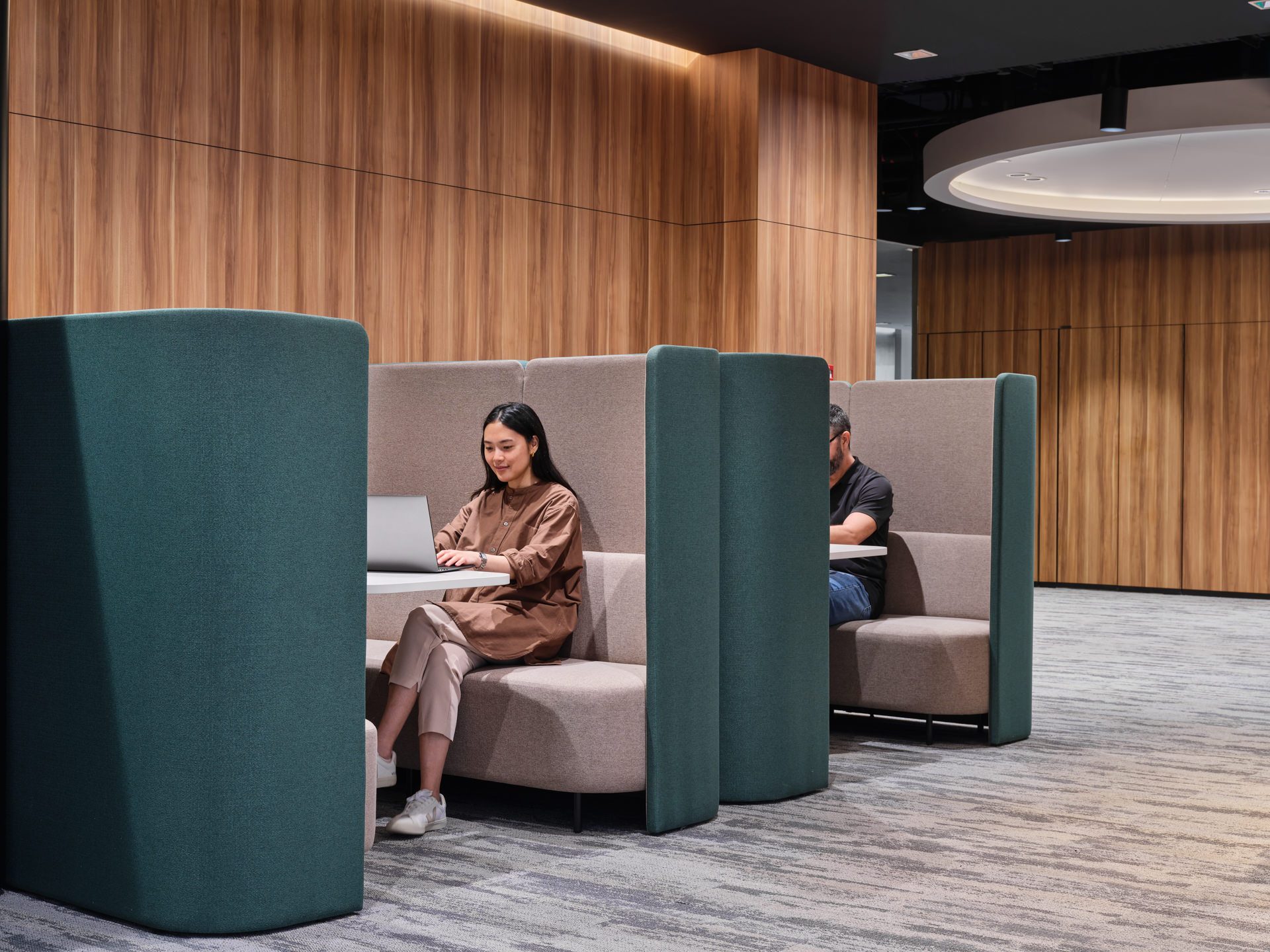 Focus nook zone with teal privacy booths and circular LED halo light