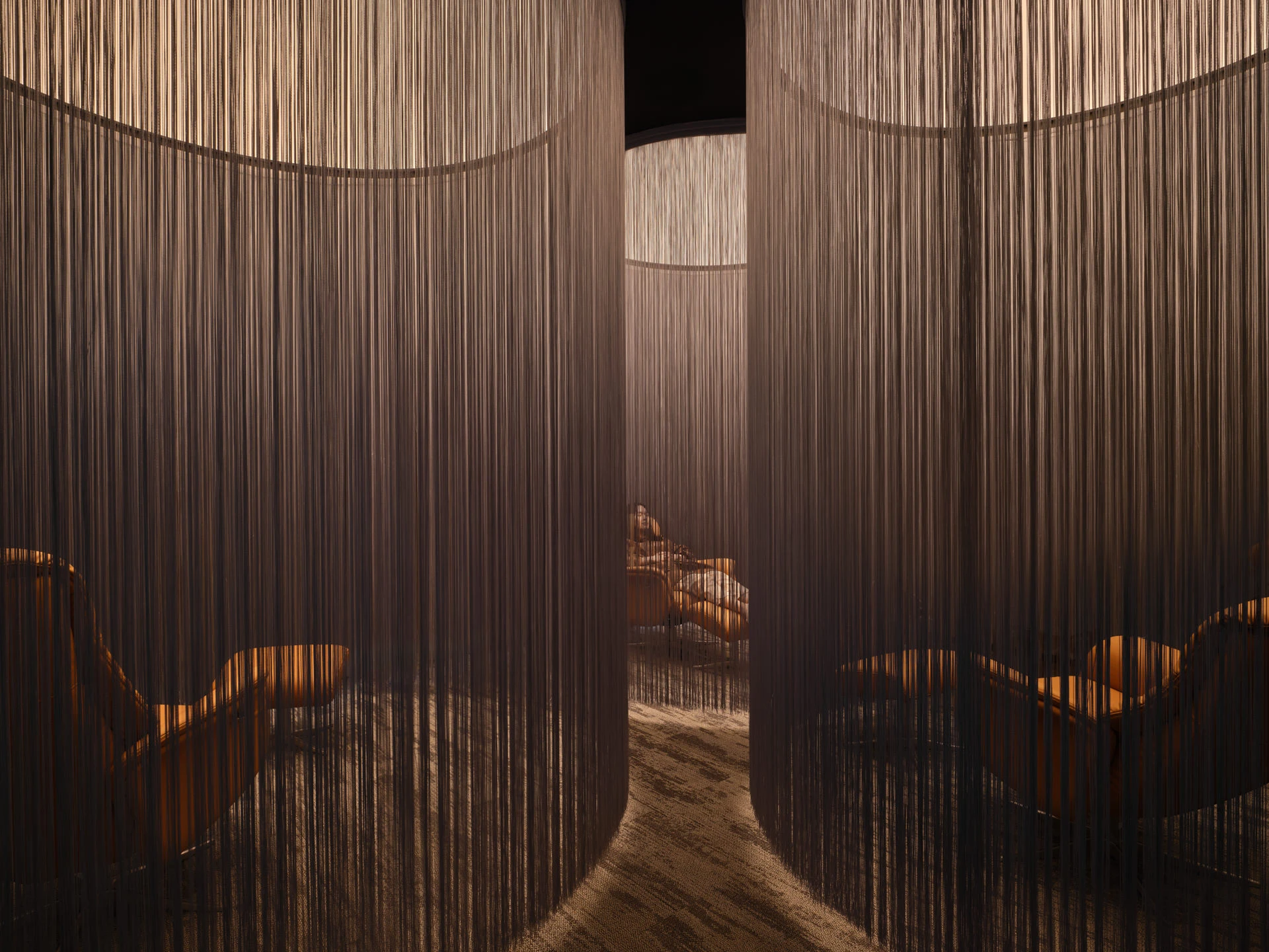 Wellness retreat room with string curtain partitions and timber loungers