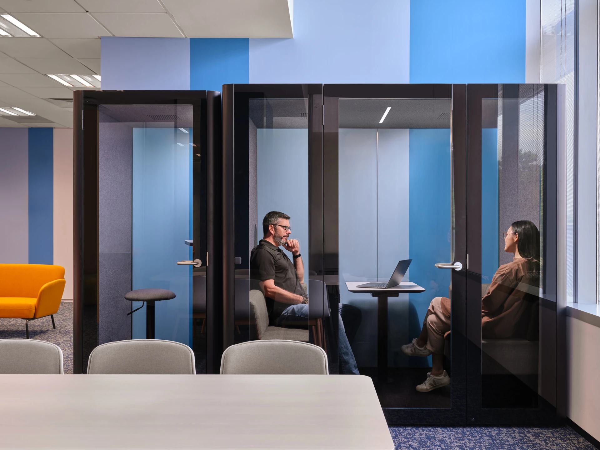 Acoustic phone pods with blue-lavender accent walls