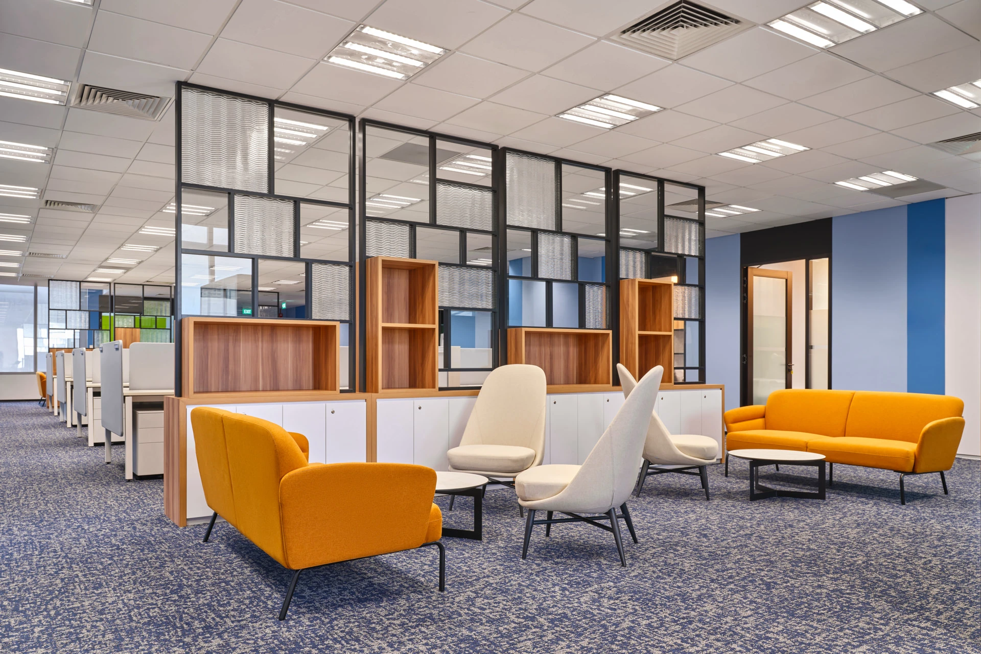 Breakout lounge with mustard armchairs and mixed-media partitions