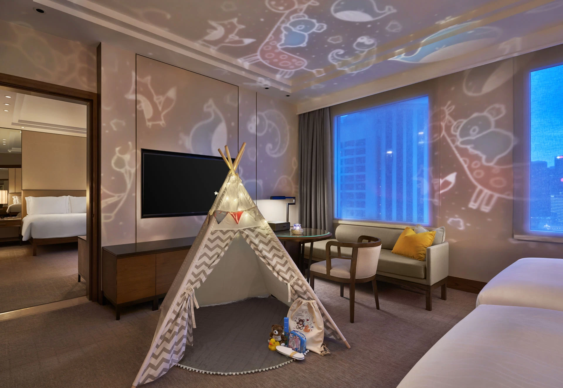 Family suite with teepee tent, fairy lights and animal projector at night