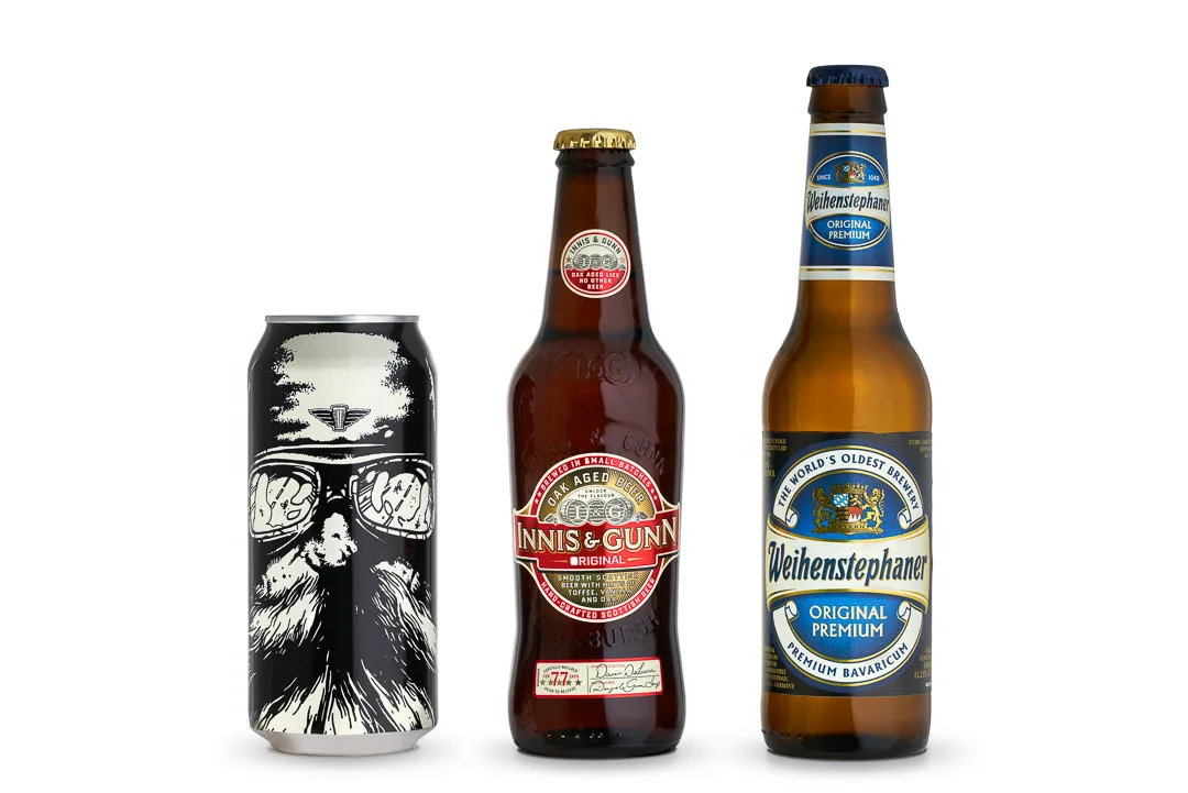 Three beers on a white background: a black illustrated craft beer can, an amber Innis and Gunn bottle, and a Weihenstephaner lager bottle.