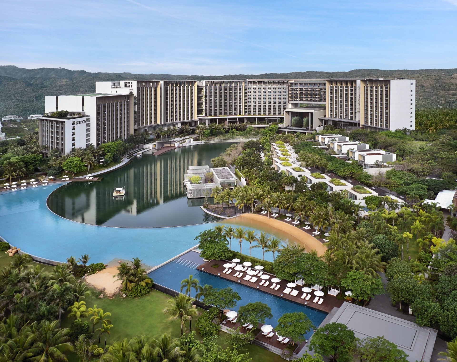 The Sanya EDITION aerial view from the sea showing oceanfront pool and property