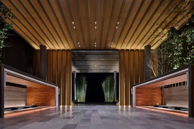 The Sanya EDITION entrance with timber-slatted porte-cochere, bamboo groves and dramatic uplighting