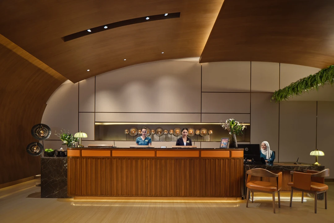Fraser Suites Sukhumvit front desk with curved timber ceiling and reception staff