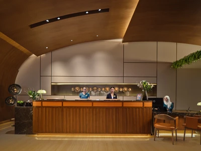 Fraser Suites Sukhumvit front desk with curved timber ceiling and reception staff