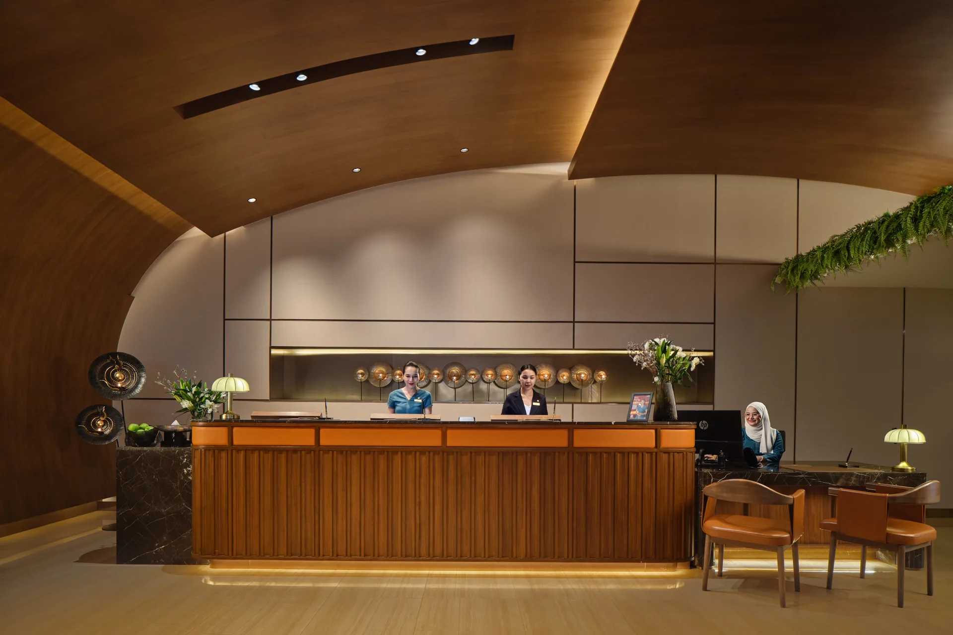 Fraser Suites Sukhumvit front desk with curved timber ceiling and reception staff
