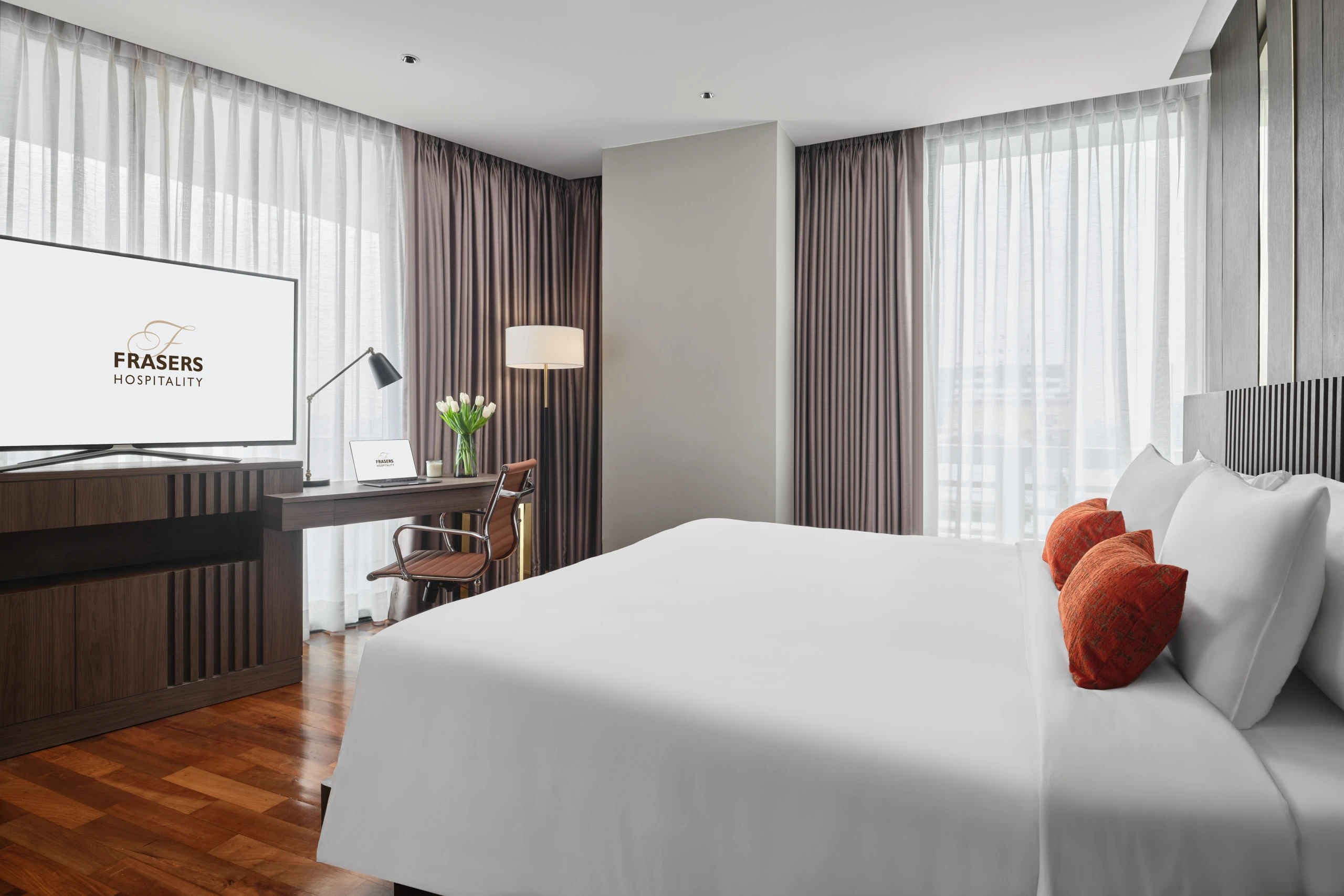 Suite bedroom with TV, work desk and drum-shade floor lamp