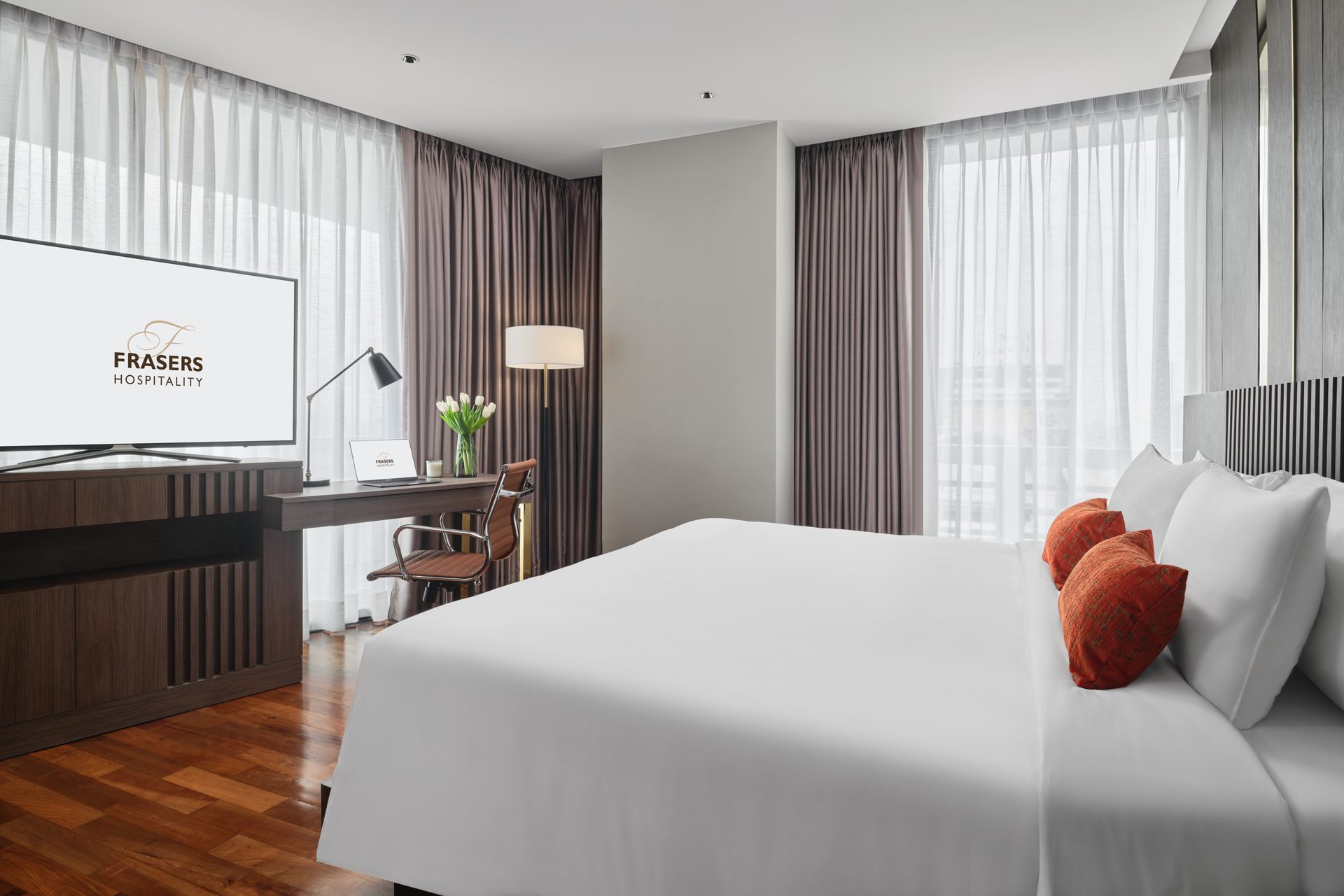 Suite bedroom with TV, work desk and drum-shade floor lamp